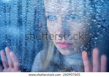 hand of young  woman  melancholy and sad  at the window in the rain