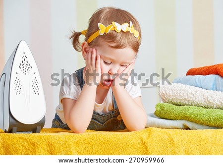 tired   cute little baby girl housewife iron clothes iron, is engaged in domestic work