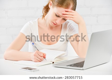 The tired business woman working at a computer