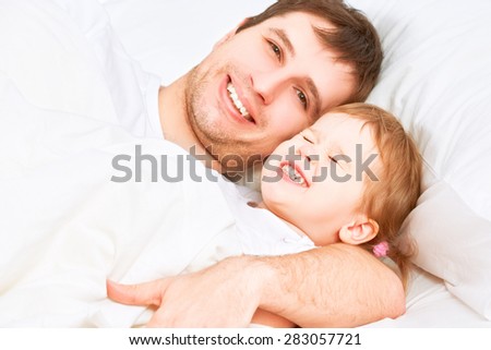the Happy family father and child baby daughter sleeping in bed