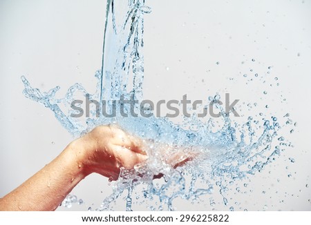 woman hand with water splashes and drops, concept of beauty and skin care