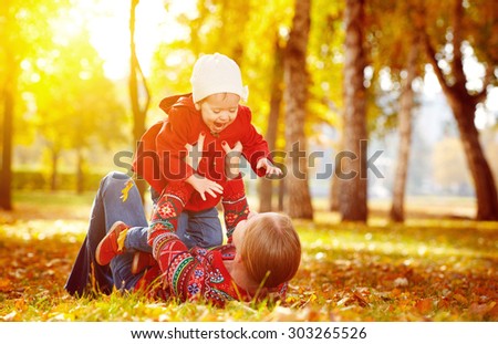 happy family: mother and child little daughter play cuddling on autumn walk in nature outdoors