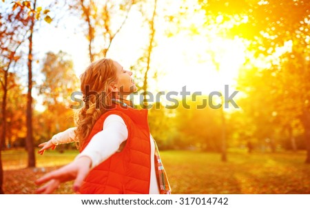 happy girl enjoying life and freedom in the autumn on the nature