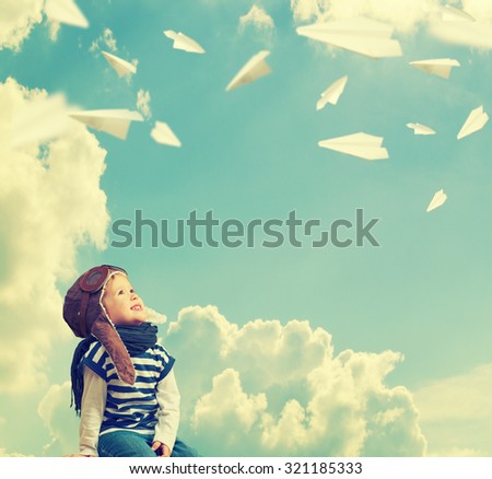 Happy child dreams of becoming a pilot aviator and plays with planes in the sky