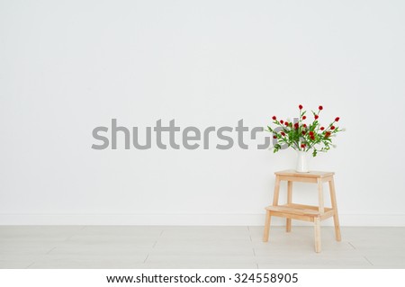 concept of a bouquet of flowers on a stepladder on the background white brick wall in an empty room