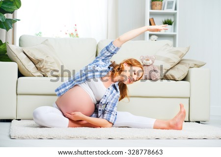 happy pregnant woman practicing yoga and fitness at home