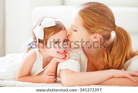 happy family. Mom kisses her little daughter child