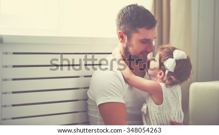 happy family child baby girl in the arms of his father at home window
