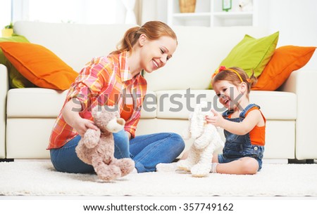 happy family mother and daughter child girl playing with toy teddy bear home