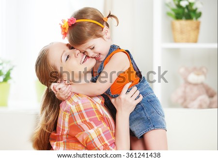 happy family mother and child girl daughter playing  laughing and hugging at home