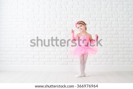 little child girl dreams of becoming  ballerina in a pink tutu skirt