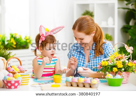 happy family mother and child girl paints eggs for Easter at home