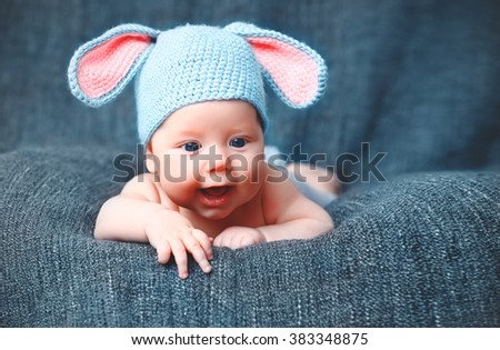 happy baby child in costume a rabbit bunny   on a grey background