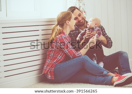 happy family mother and father playing with a baby at home