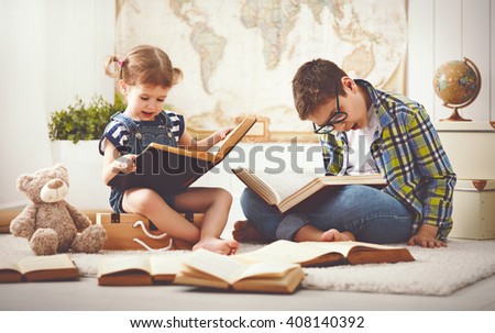 children brother and sister, boy and girl reading a book at home