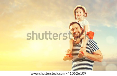 happy family father and child daughter playing and having fun in the summer by the sea on the beach