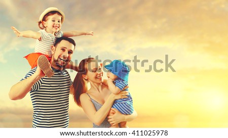 happy family of father, mother and two children, baby son and daughter on  the beach at sunset