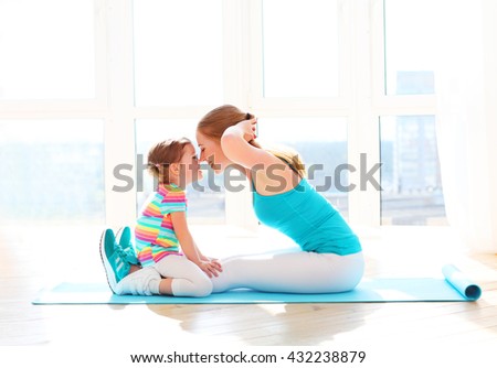 family mother and child daughter are engaged in fitness, yoga, exercise at home
