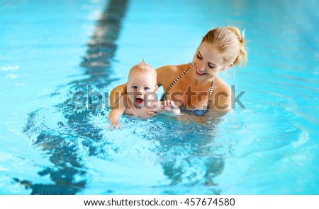 healthy family mother teaching baby swimming pool