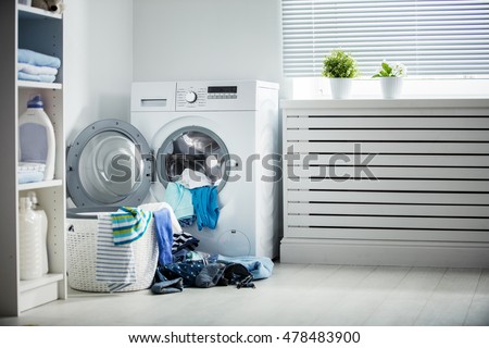 laundry. A washing machine and a pile of dirty clothes at home