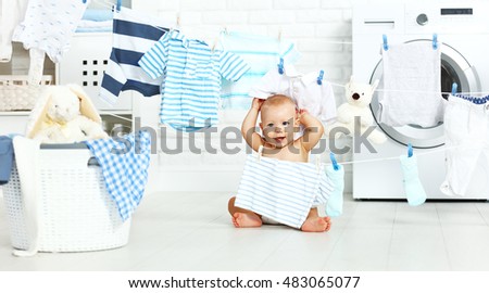 fun happy baby boy  to wash clothes and laughs in the laundry room