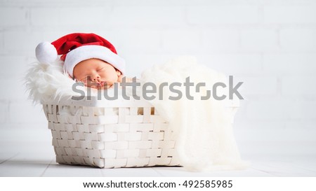 sleeper newborn baby in a Christmas Santa cap