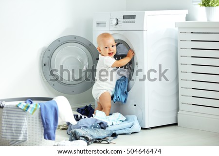 fun happy baby boy  to wash clothes and laughs in the laundry room
