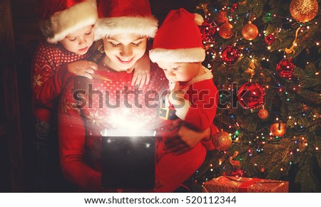 happy family on Christmas Eve. mother and children discover a magical gift at the tree