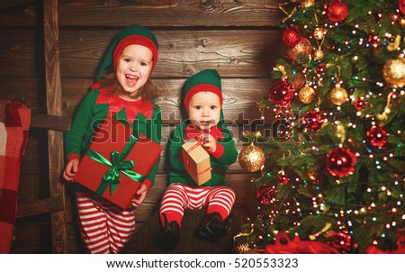 happy children brother and sister  elf, helper of Santa with a Christmas gifts