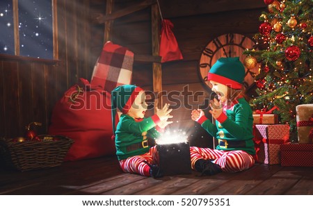 happy children brother and sister  elf, helper of Santa with a Christmas  magic  gifts