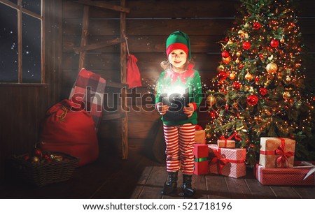 happy child girl elf helper of Santa with a magic Christmas gift