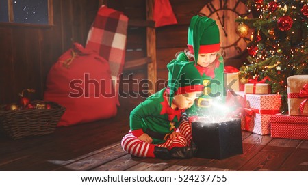 happy children brother and sister  elf, helper of Santa with a Christmas  magic  gifts