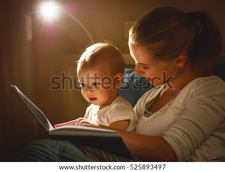 mother and baby sonreading a book in bed before going to sleep