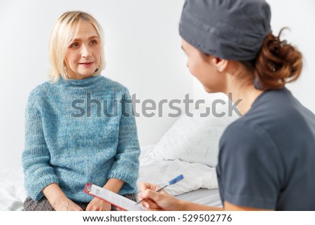 friendly nurse and an old patient in a clinic