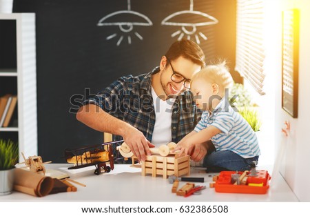 Happy family father and son toddler gather craft a car out of wood and play