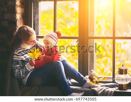 happy family mother and baby son in autumn window