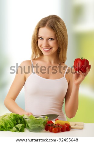 fun happy young woman preparing vegetarian food, vegetables in the kitchen