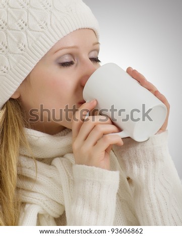 beautiful girl in winter clothes drinking warming drink