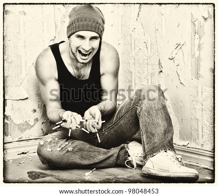 bad man - drug dealer with syringes and  with drugs sitting on the floor