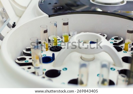 Test tubes in centrifuge with yellow fluid in white medicine laboratory