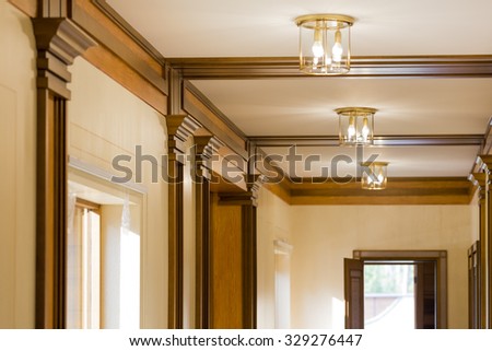 Interior corridor in ecological house.Illuminated light bulb on the ceiling.The wide windows with views of green garden. Design facilities new and modern.