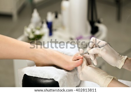 Woman receiving cuticle in manicure pedicure salon