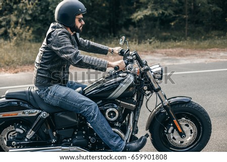 Front view of motorcycle driver driving in beautiful sunset. Freedom and travel concept.
