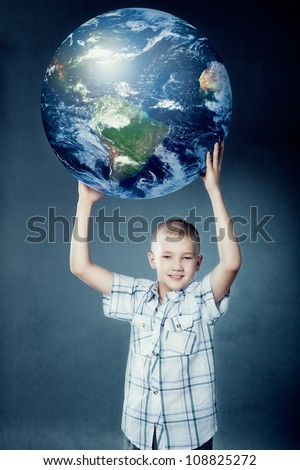 Child holding the earth in his hands on gray background. Elements of this image furnished by NASA.
