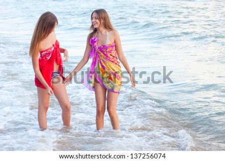 Two young womens in a pareo on the sea