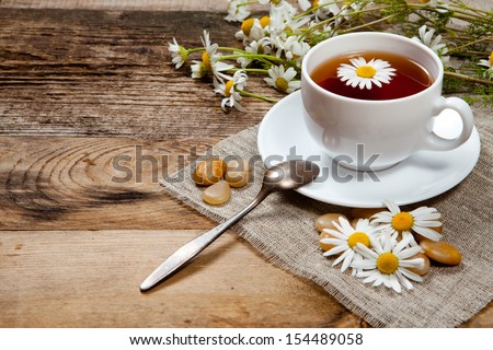 herbal tea with chamomile on old wooden table