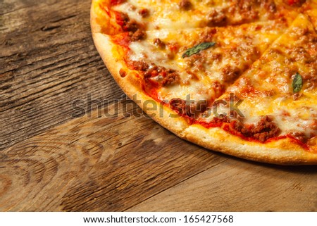 Bolognese pizza on old wooden table. With place for text.