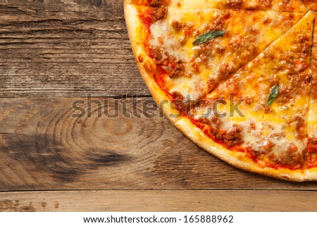 Bolognese pizza on old wooden table. Top view with place for text.