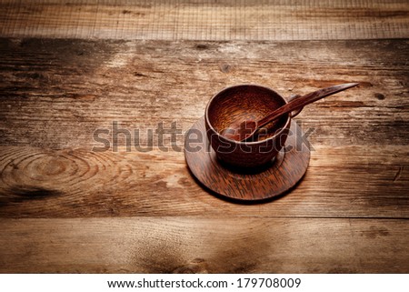 Wooden cup with spoon on old wooden table