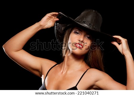 Woman in a cowboy hat. On black background.